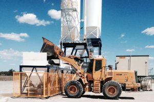 Digger loading a hopper | Featured Image for the Concrete Batching Plants Page of CMQ Engineering USA.
