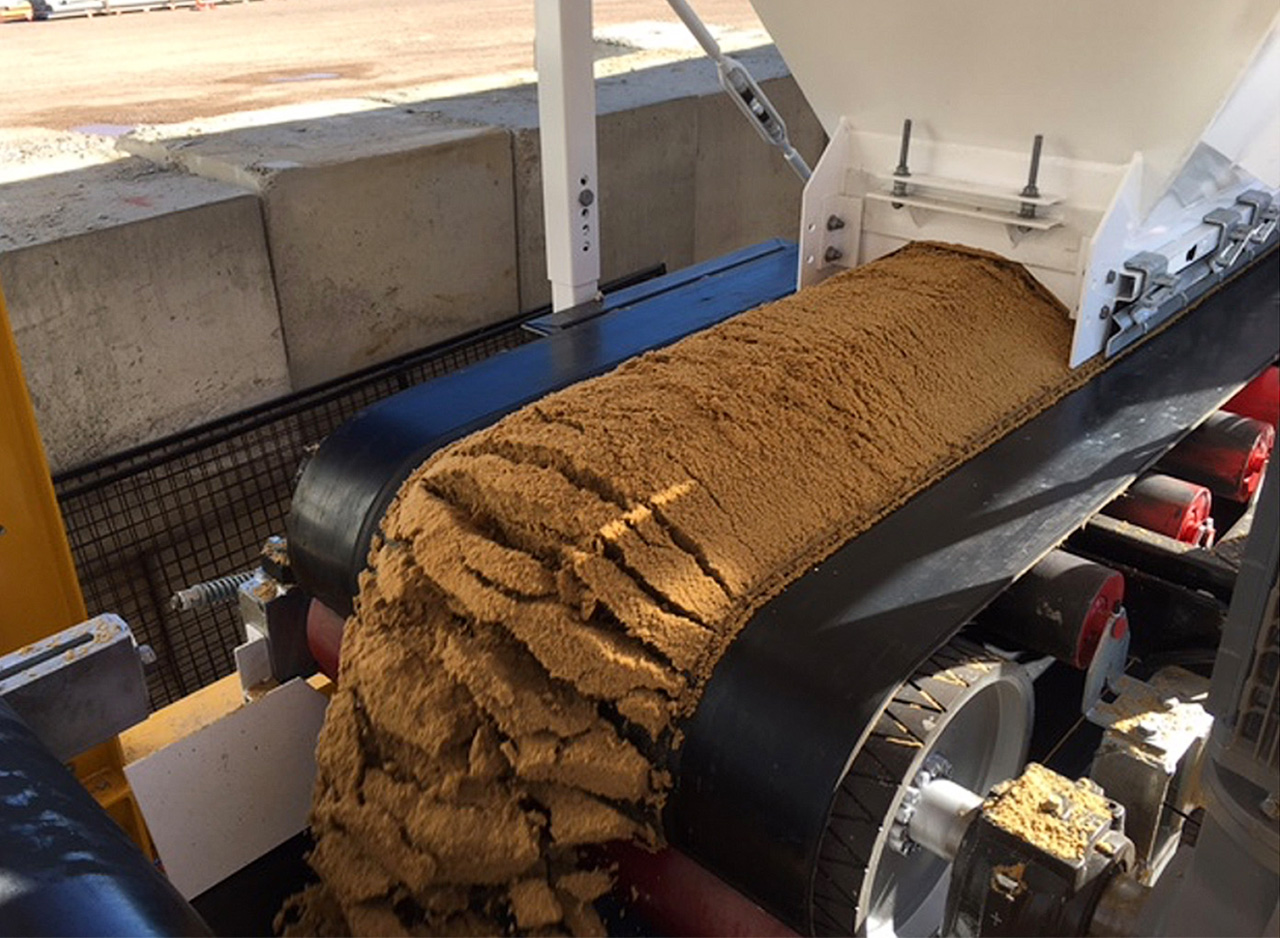 Sand being metered on a CMQ Engineering precision weigh belt.
