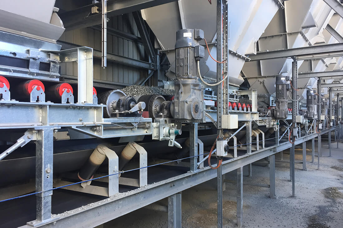 Dedicated aggregate weigh belts underneath each aggregate bin of the Advantage 250 concrete batch plant | Image for the Concrete Batch Plant Manufacturers page.