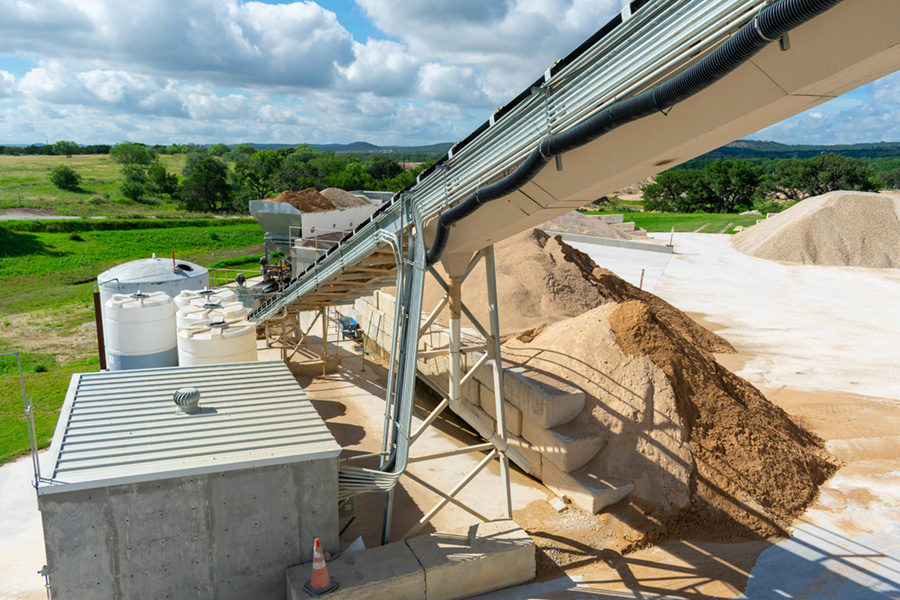Ready mix concrete plant near Kerrville, Texas, with charging conveyor set 45 degrees to the aggregate blending unit.