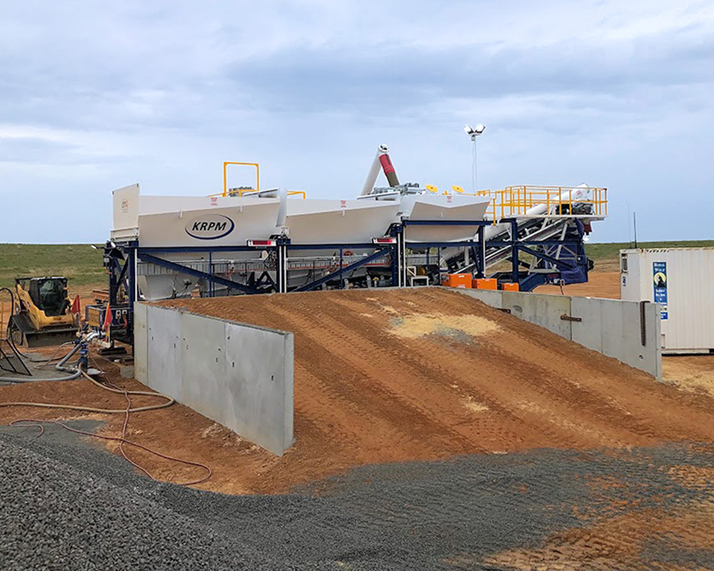 DualBatch mobile concrete plant in the field. This view shows an earthen ramp for loading the aggregate weigh hoppers.